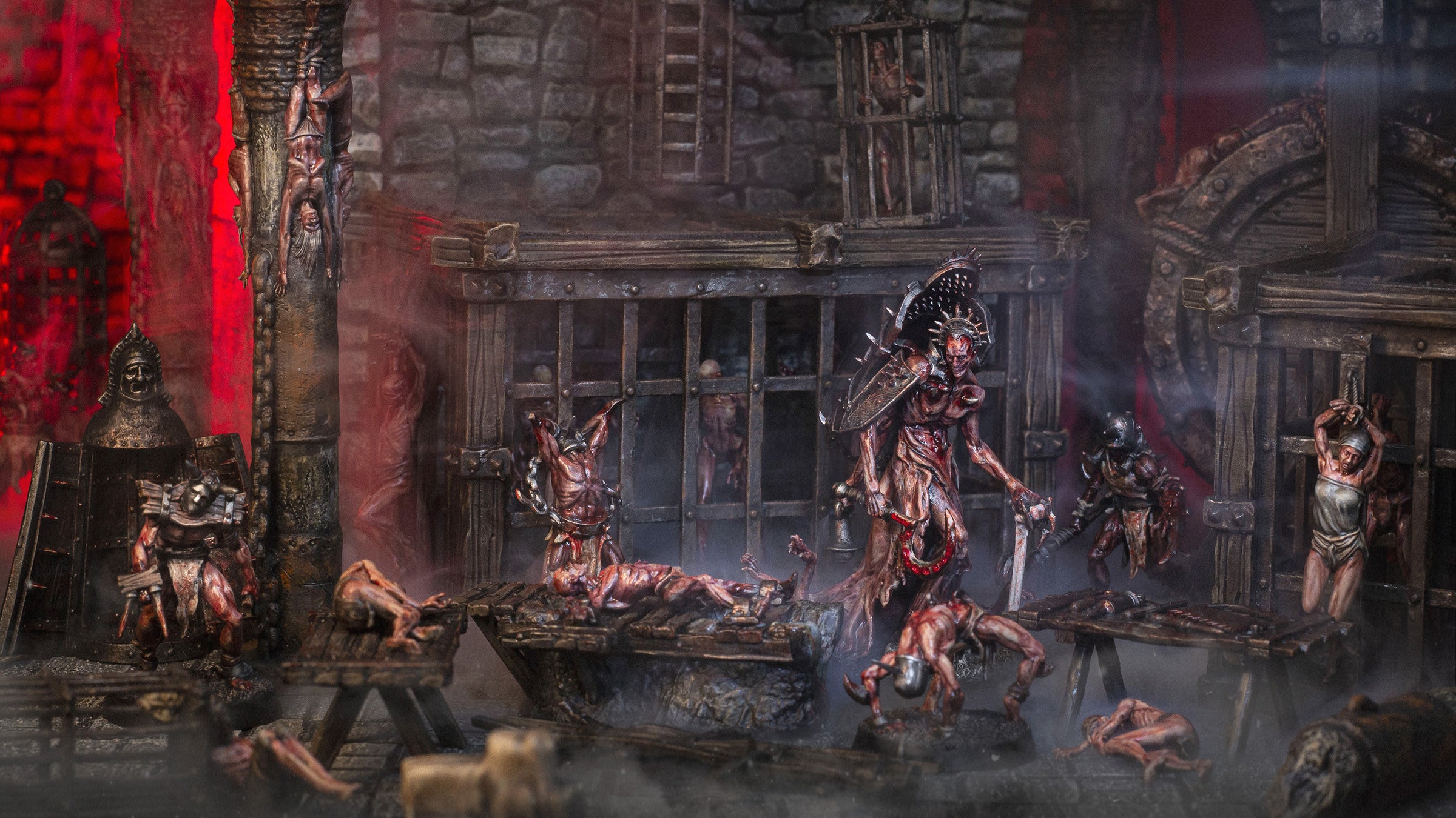 Grimdark dungeon diorama featuring Anatomists miniatures inside a torture chamber with prison cells, surgical tools and stone walls.